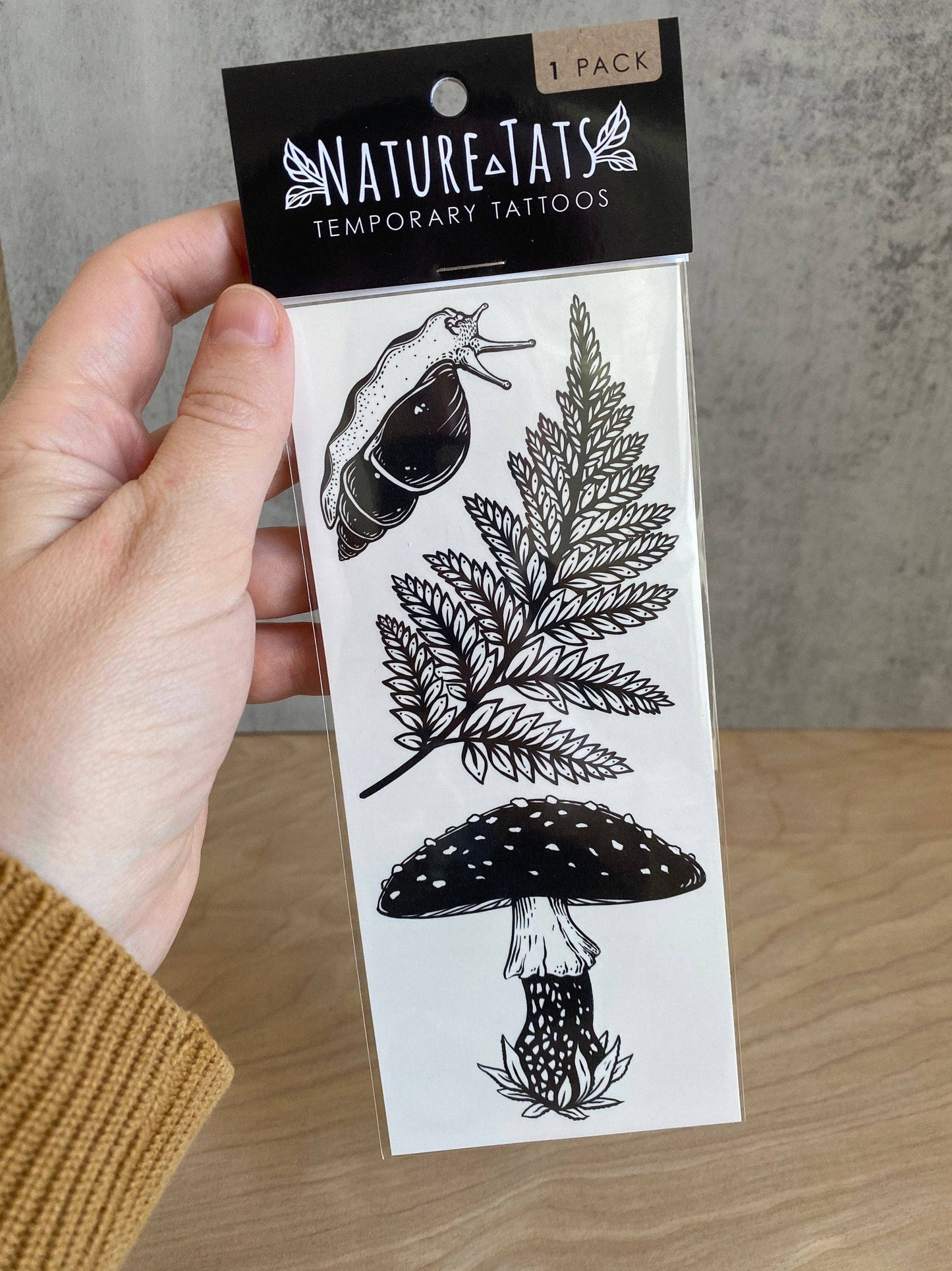 Tatuaje temporal de hongo amanita, helecho y caracol