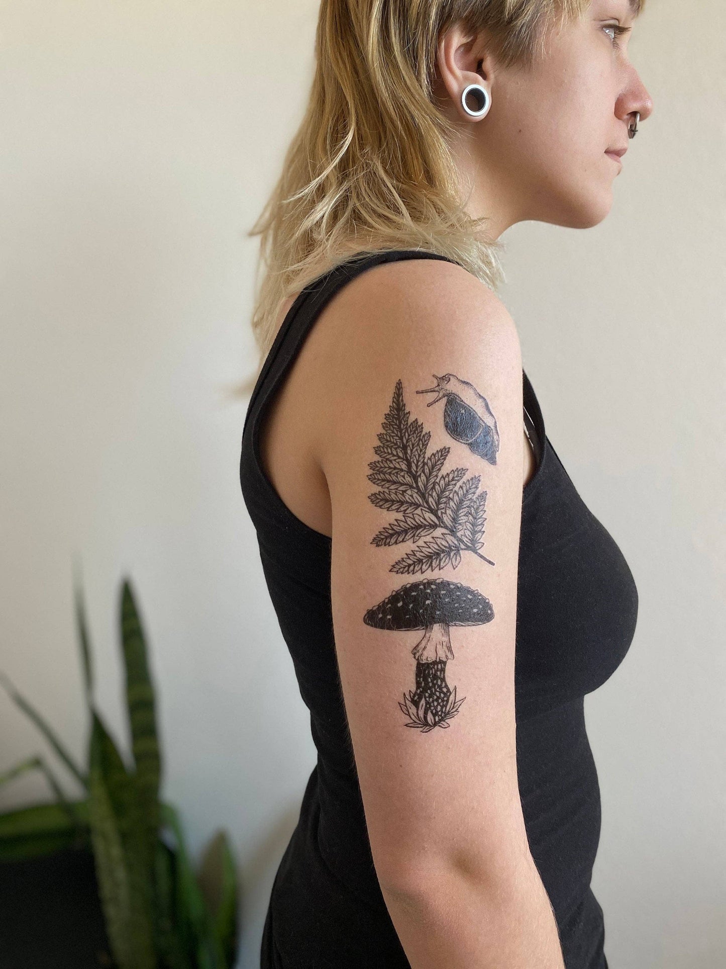 Tatuaje temporal de hongo amanita, helecho y caracol
