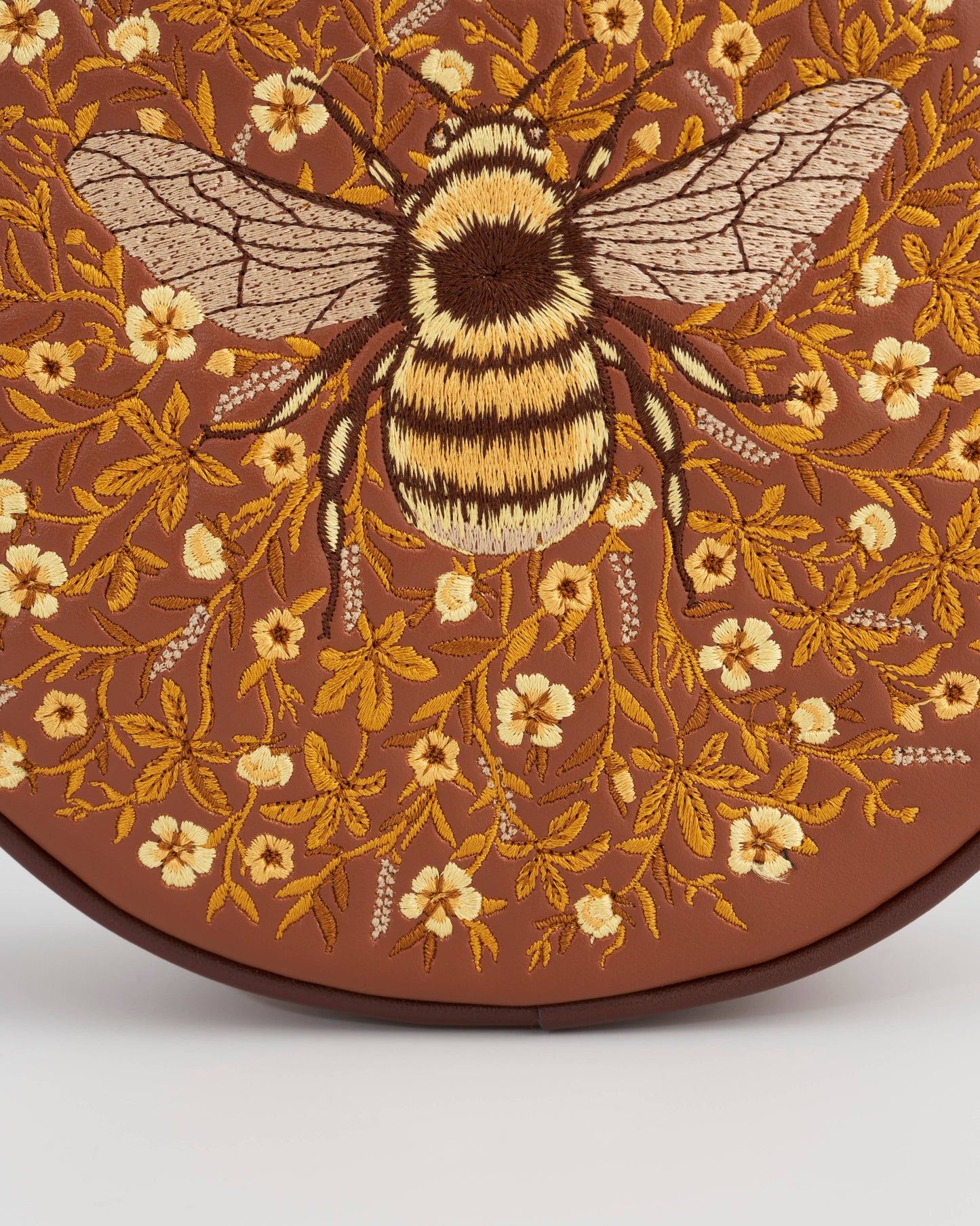 Monedero circular color canela con bordado de abejorro